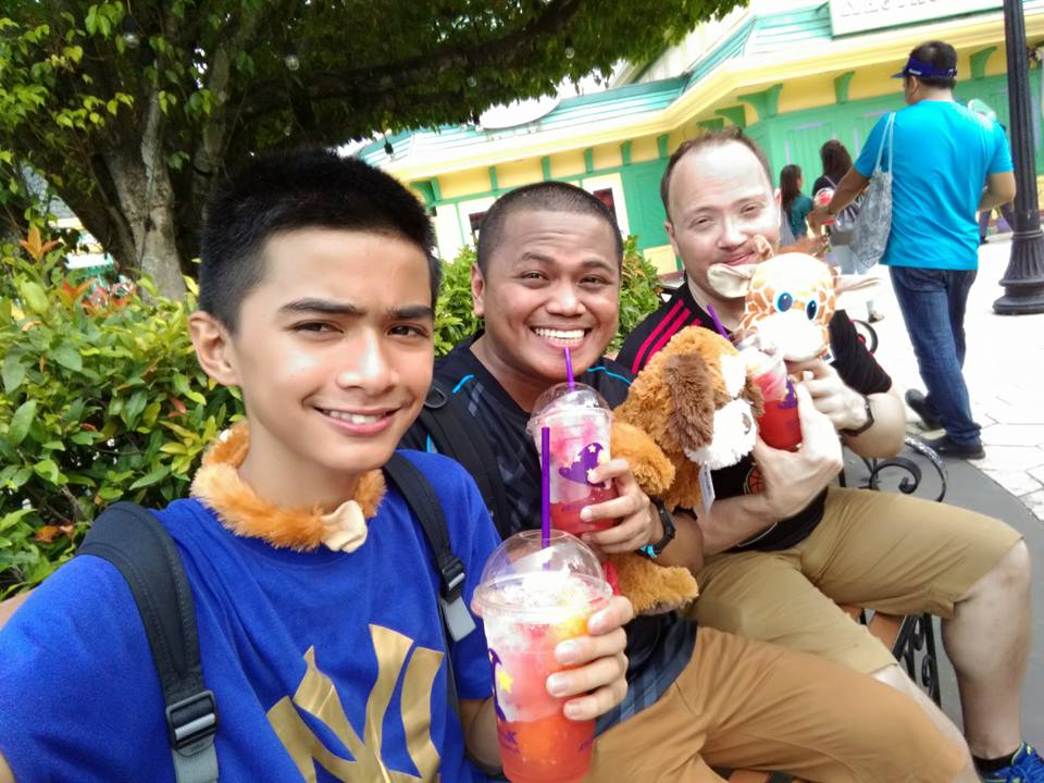 3 men slurping cold drink in a theme park