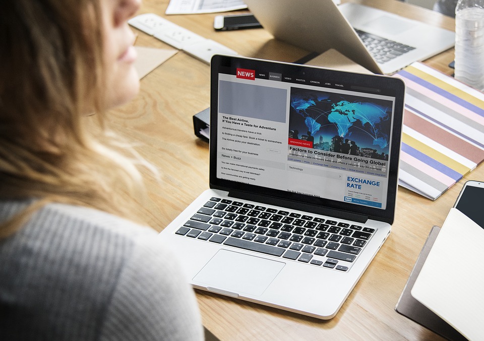 Young lady reading latest news on a laptop