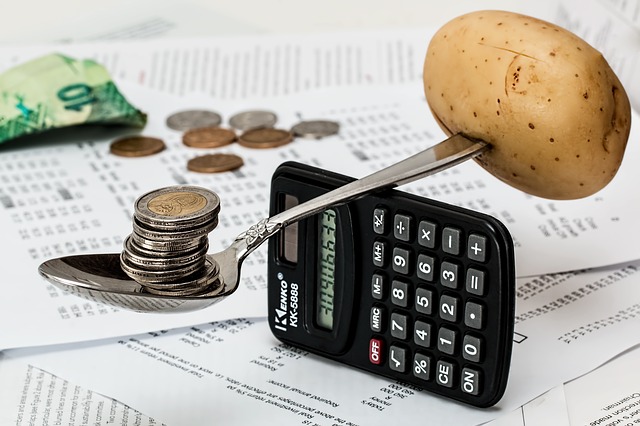 Coins and Potato spoon Balancing on a calculator