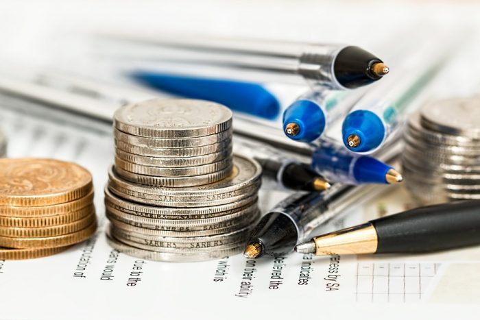 Coins and pens above the paper