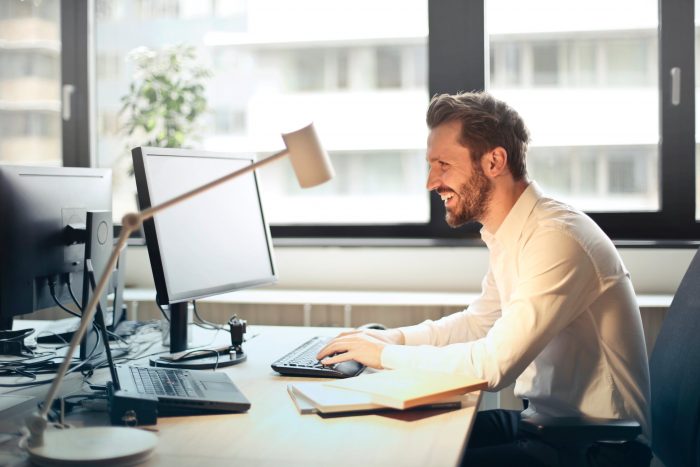 Man Smiling while working on desktop