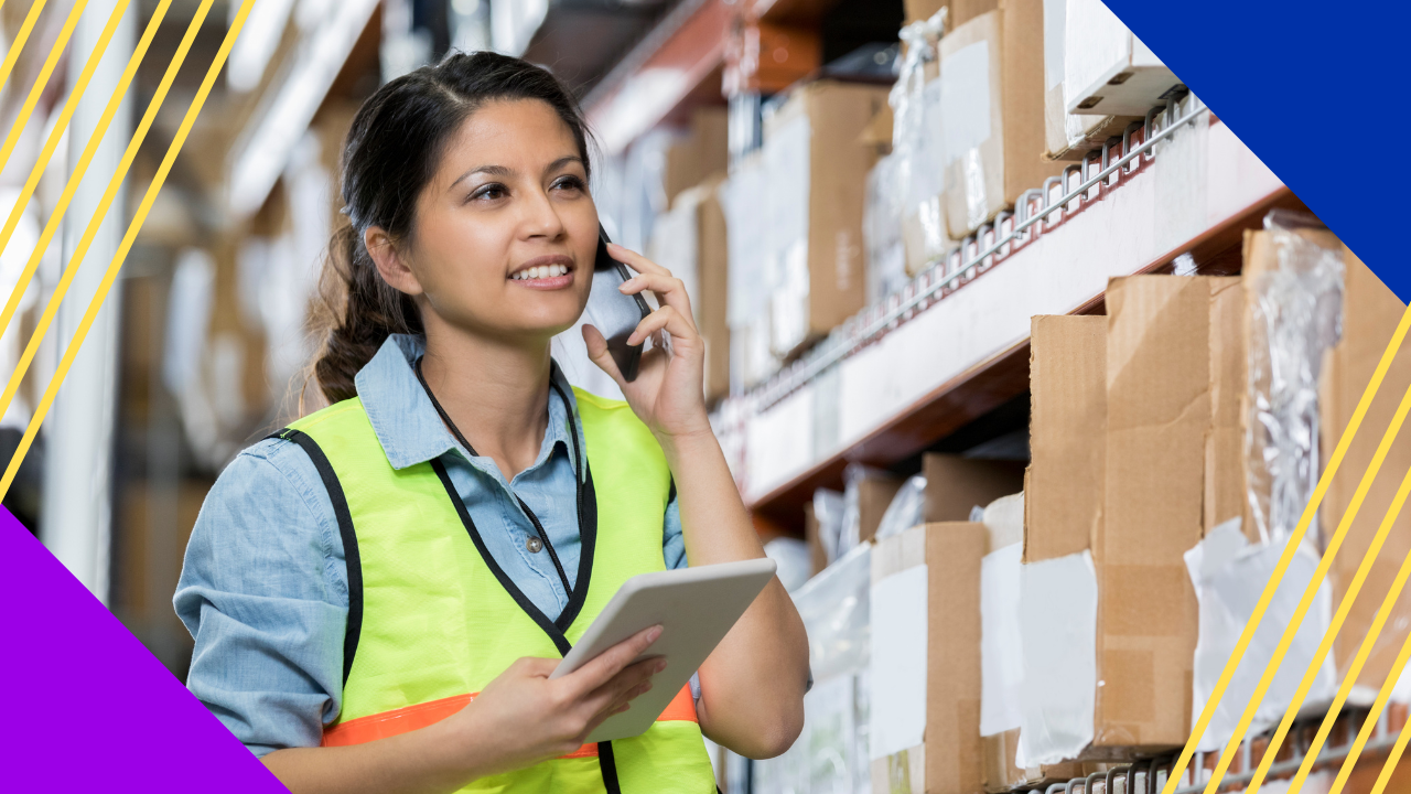 female distribution warehouse supervisor uses smart phone to talk
