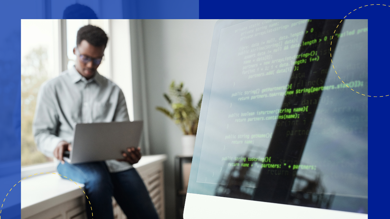 blurred portrait of young african-american man using laptop while sitting by window in software development office