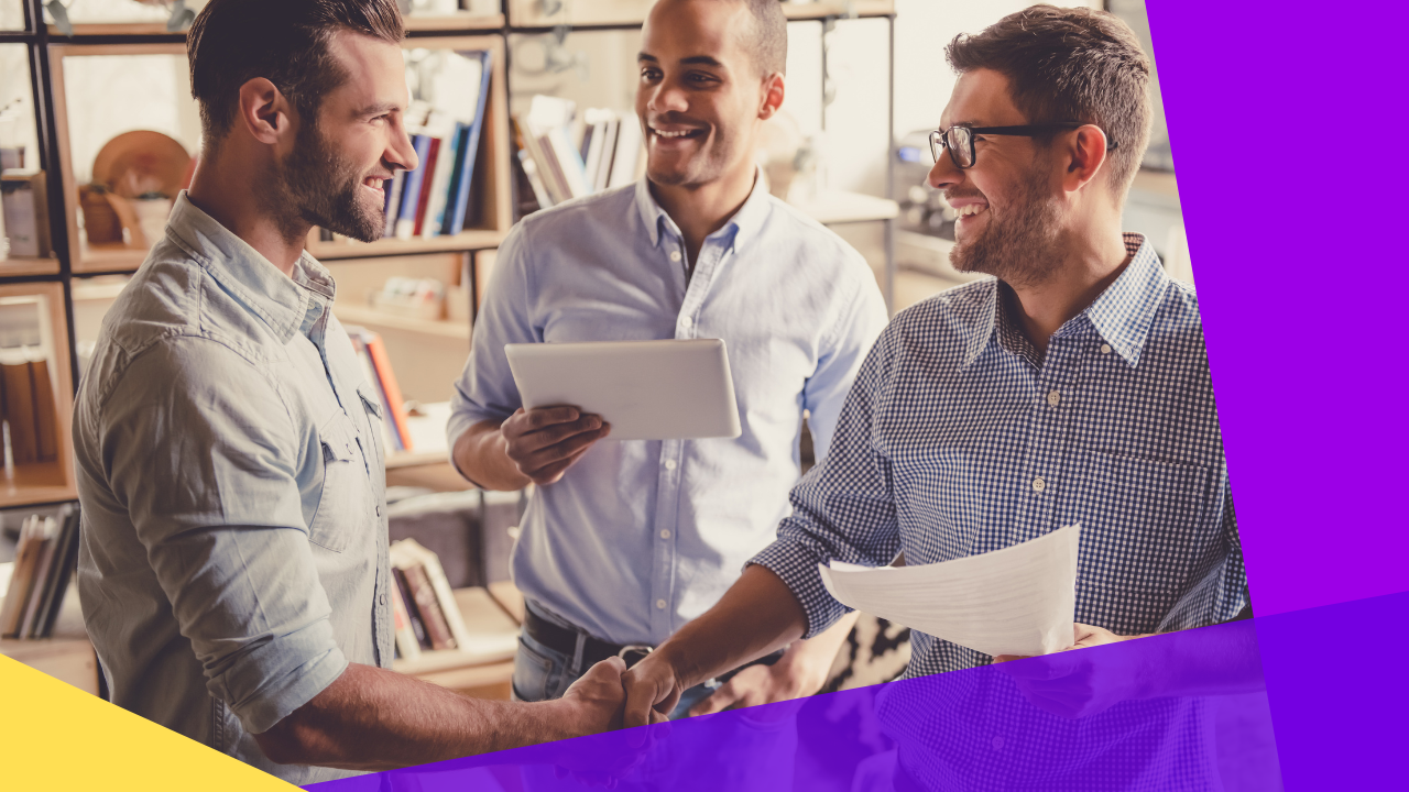 handsome businessmen are shaking hands and smiling while standing in office