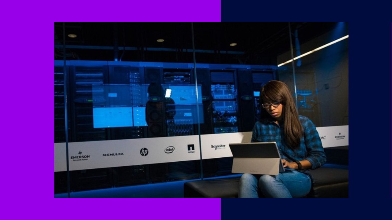 Woman working on laptop in server room, cost-effectiveness of managed IT support services