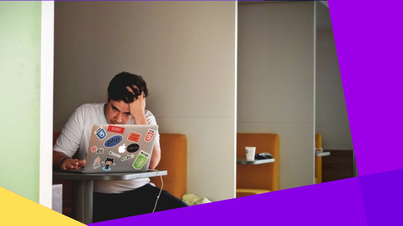 Man stressed at laptop, identifying virtual assistant job scams.