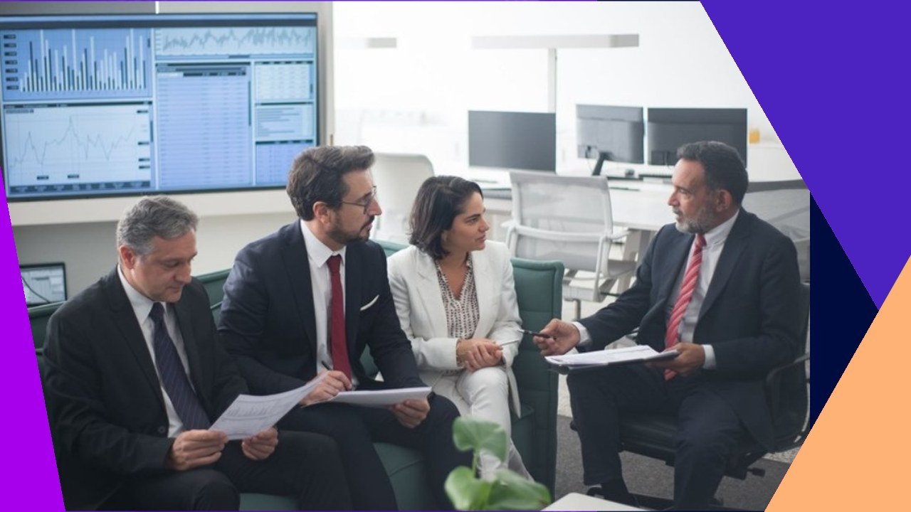 Financial professionals review data on screen, discussing financial services outsourcing strategies.