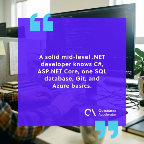 .NET developer — a Windows workstation showing C# source code on a large monitor