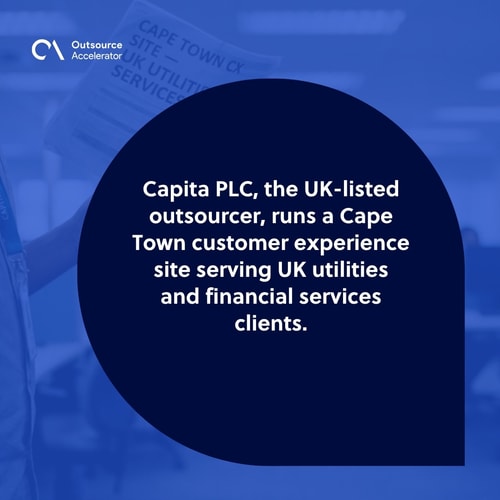 Capita PLC operations manager at the far-left edge of a Cape Town contact-centre floor holding a printed staffing report for UK utilities and financial-services queues