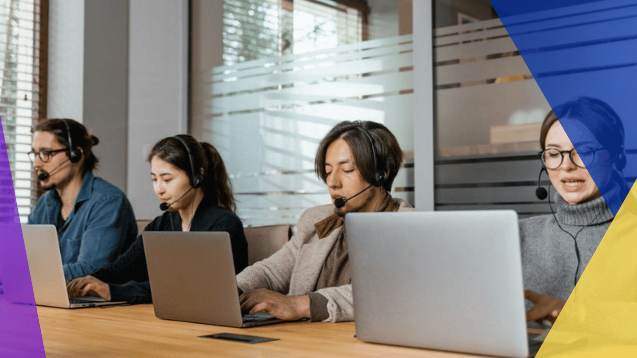 Bilingual call center - four support agents with headsets working at laptops