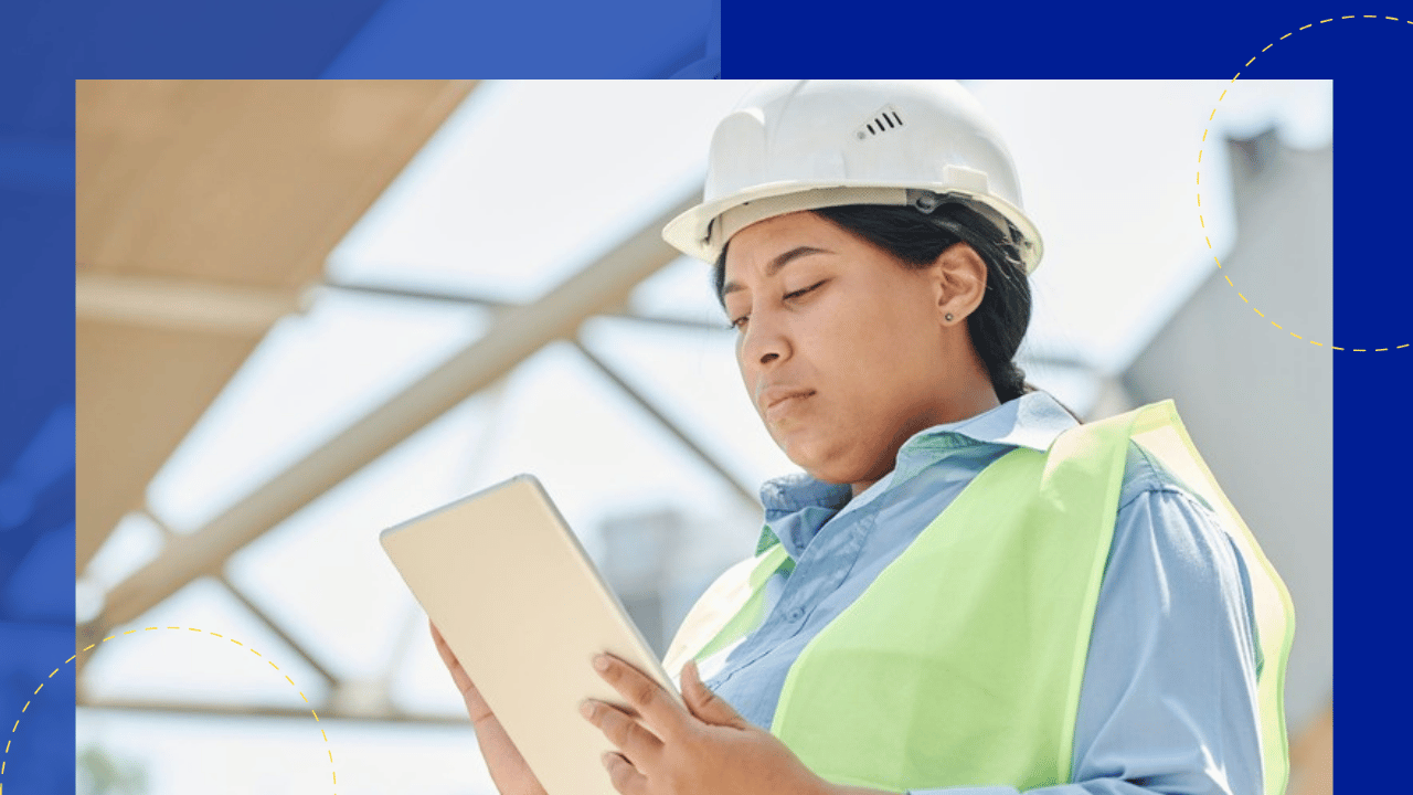 construction contract administration - an engineer in a hard hat checking a tablet on a construction site