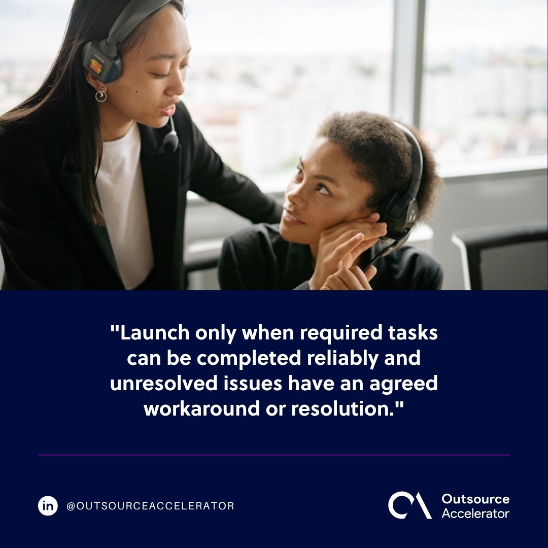 outsourced call center onboarding - team lead coaching an agent on a headset at a desk