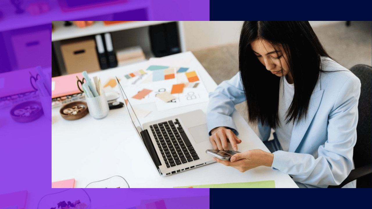 Virtual assistant hybrid roles - a professional juggling phone and laptop tasks at her desk